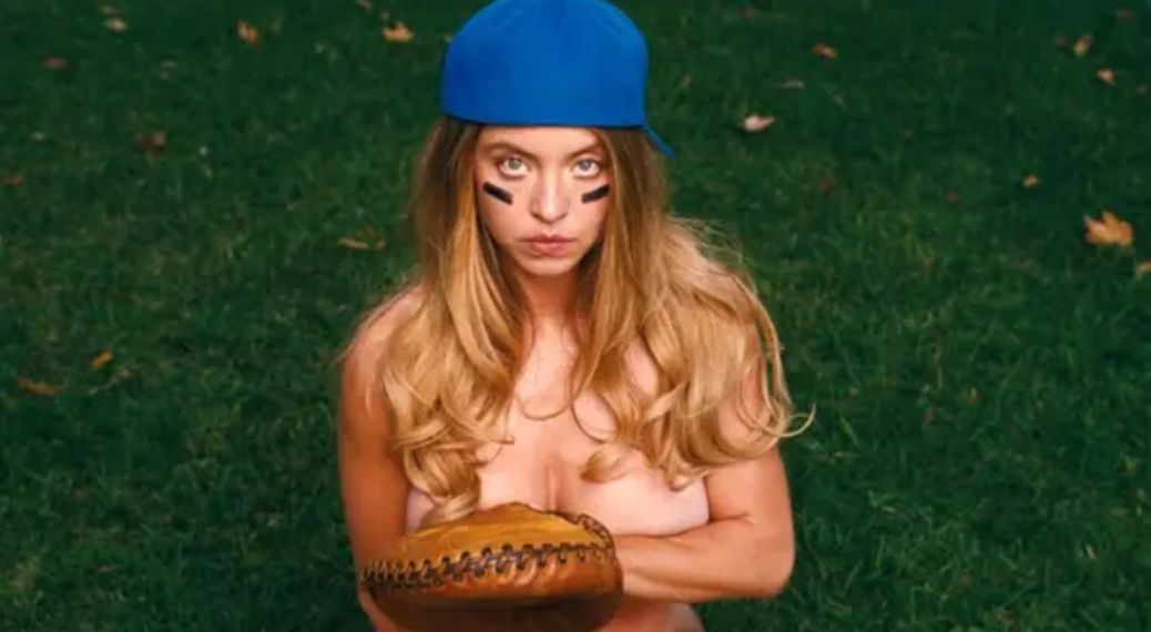 Sydney Sweeney in a baseball-themed setup, where she appears almost entirely undressed, using minimal props to cover herself.